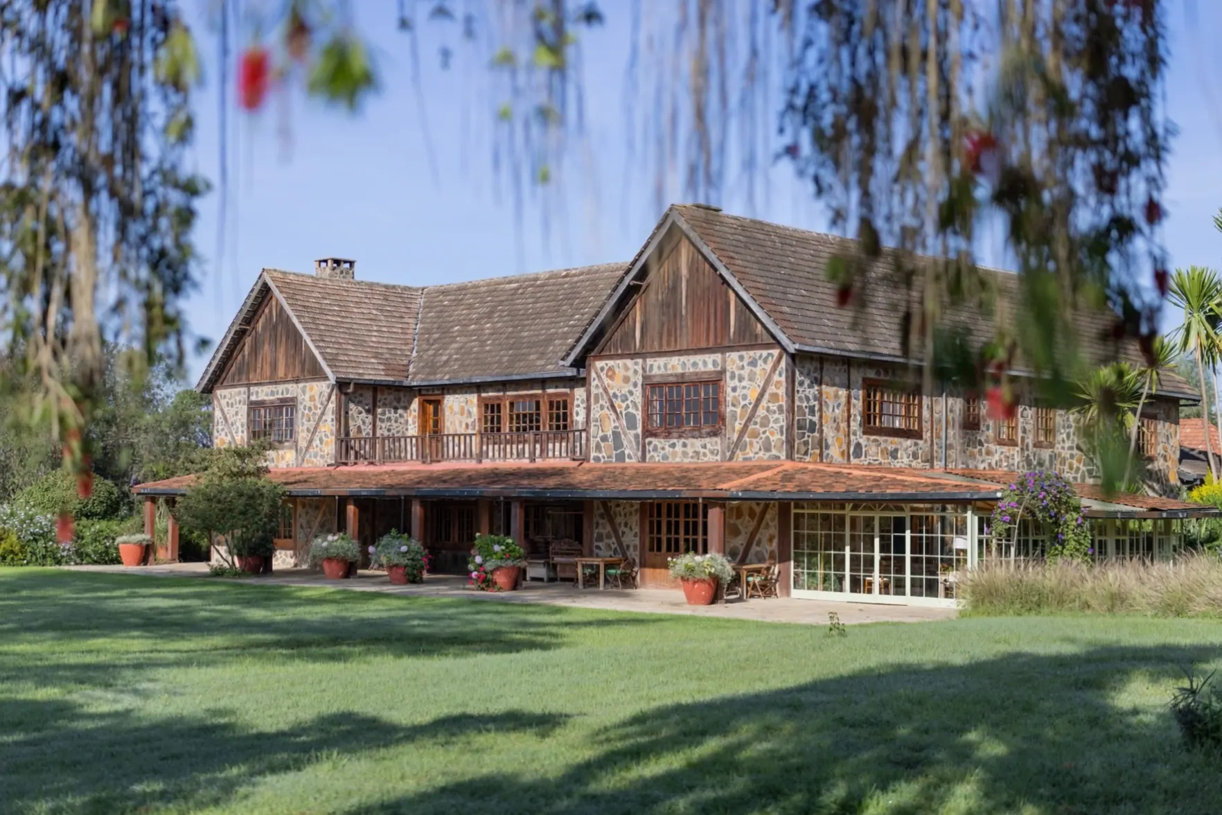 The Manor House at Mukima, seen across the lawn through flowering bottlebrush
